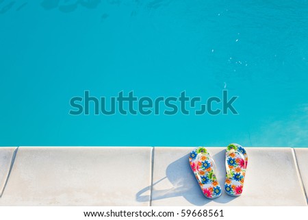 flip-flops with flowers near  swimming-pool