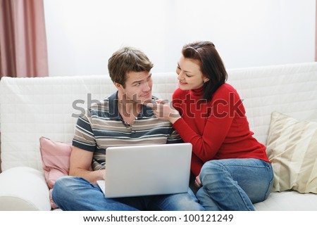 Young woman trying to distract boyfriend from laptop