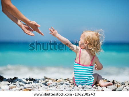 Baby pulling hands to mother
