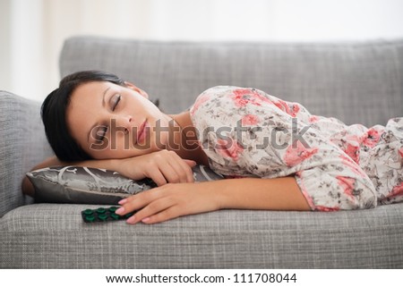 Young woman sleeping with pack of pills