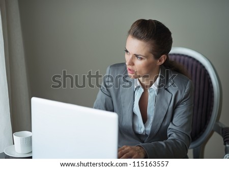 Thoughtful business woman in hotel room looking in window