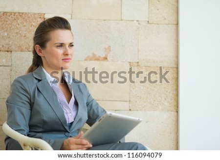 Business woman holding tablet PC and looking on copy space