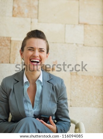 Laughing business woman sitting on chair