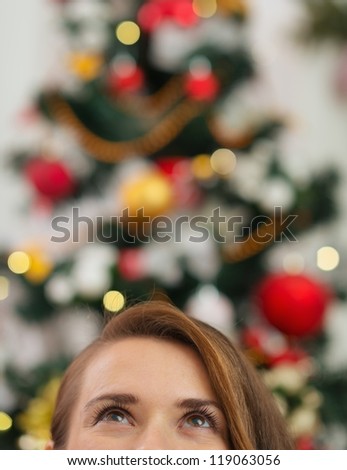 Closeup on female head in front of Christmas tree looking up