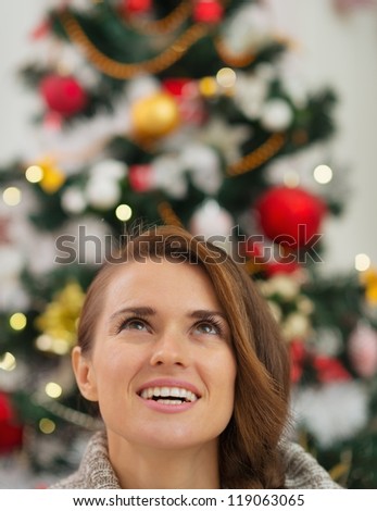 Woman in front of Christmas tree looking up