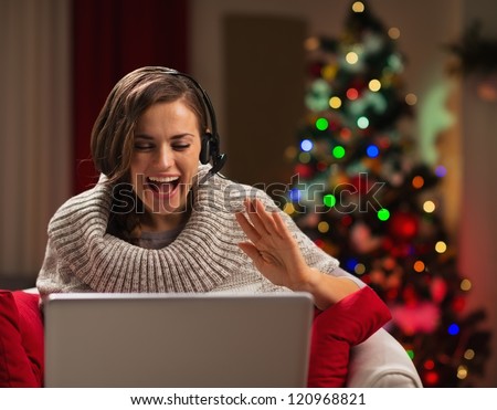 Happy young woman having Christmas video chat with family