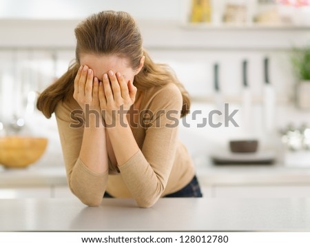Stressed young woman in kitchen