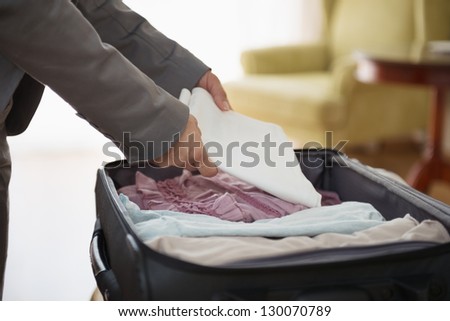Closeup on business woman unpack luggage in hotel room