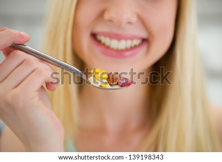 Closeup on spoon with flakes in hand of smiling teenager girl