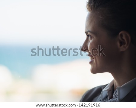 Silhouette of business woman looking into window