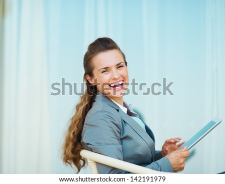 Smiling business woman using tablet pc on terrace