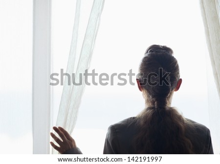 Silhouette of business woman looking into window
