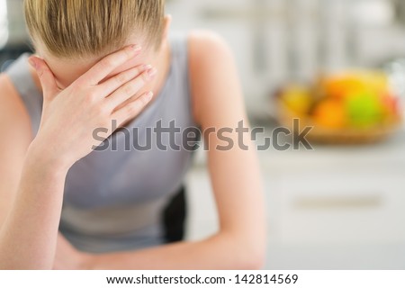Portrait of stressed young housewife in modern kitchen