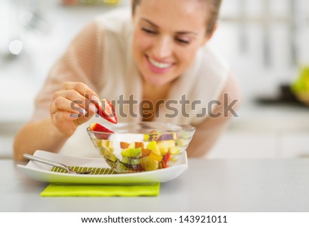 Happy Young Housewife Decorating Fruits Salad