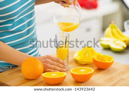 Closeup on woman pouring juice into glass