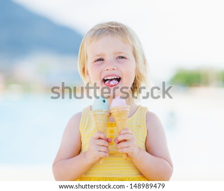 Happy baby eating two ice cream