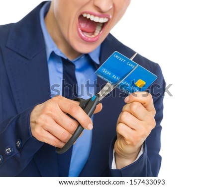 Closeup on angry business woman cutting credit card with scissors