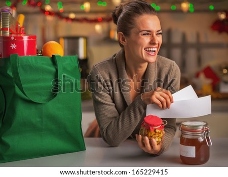 Smiling young housewife with receipts from christmas purchases