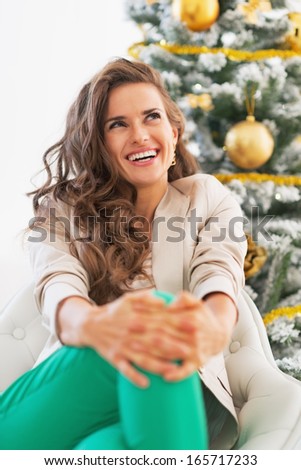 Portrait of happy young woman near christmas tree