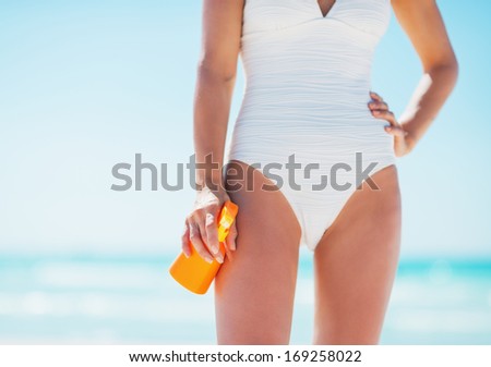 Closeup on young woman with sun block creme