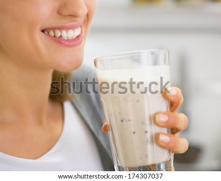 Closeup on young woman drinking smoothie