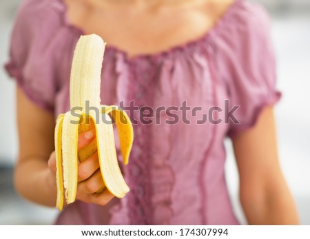 Closeup on young woman holding banana