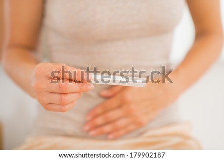 Closeup on young woman holding pregnancy test
