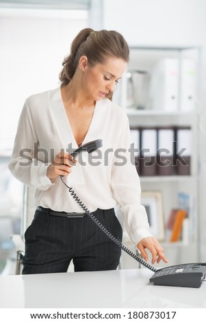 Modern business woman dialing phone