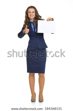 Full length portrait of happy business woman showing blank paper sheet and thumbs up