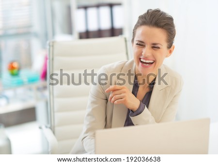Laughing business woman with laptop