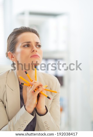 Portrait of thoughtful business woman holding pencils