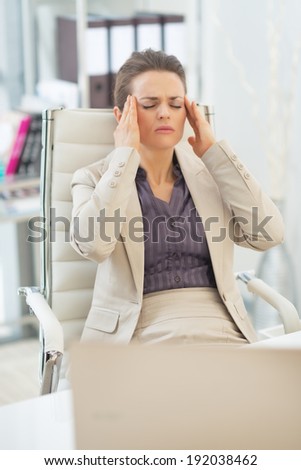 Portrait of business woman with head ache in office