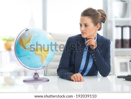 Business woman looking on earth globe