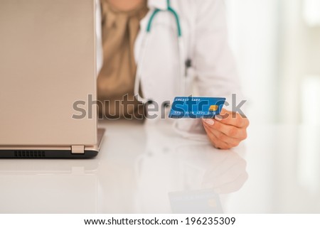Closeup on medical doctor woman with credit card using laptop