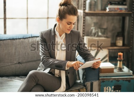 Happy business woman using tablet pc in loft apartment