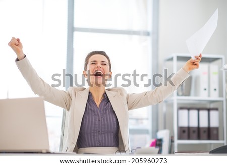 Happy business woman with document rejoicing at work