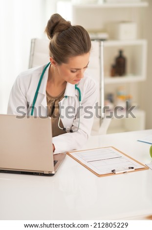 Doctor woman working on laptop in office