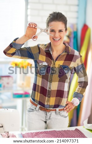 Happy tailor woman showing scissors