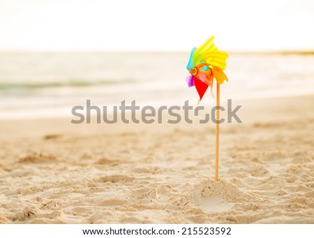 Ã?Â?Ã?Â�olorful windmill toy standing on the beach in the evening