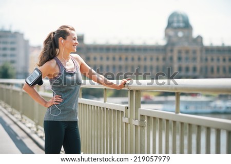 Portrait of fitness young woman in the city looking into distance