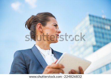 Business woman with tablet pc in front of office building