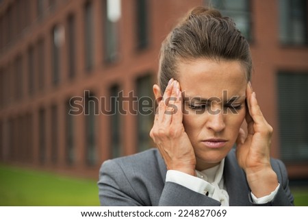 Portrait of stressed business woman in front of office building