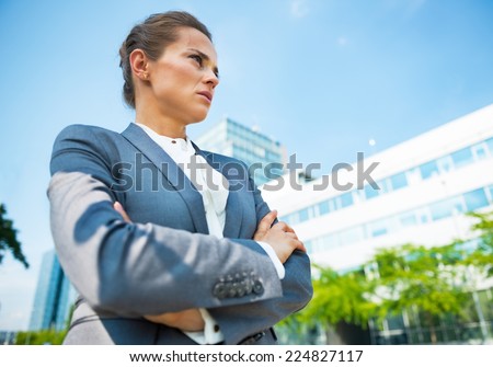 Serious business woman in front of office building