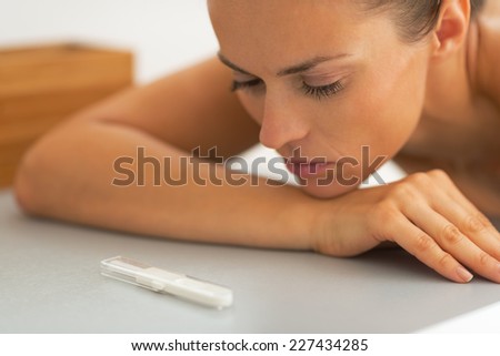 Portrait of young woman looking on pregnancy test
