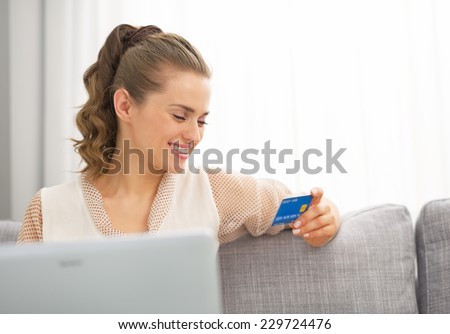 Happy young housewife looking on credit card