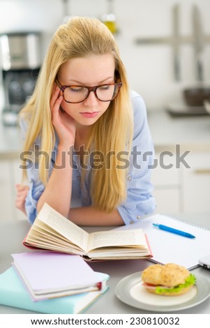 Portrait of tired young woman studying in kitchen