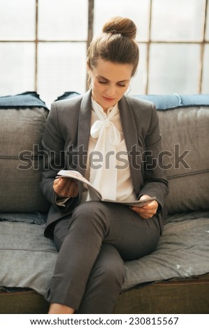 Business woman reading magazine in loft apartment