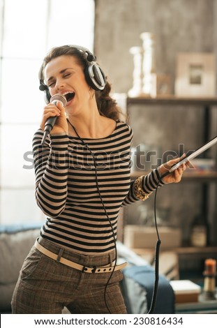 Young woman singing karaoke in loft apartment