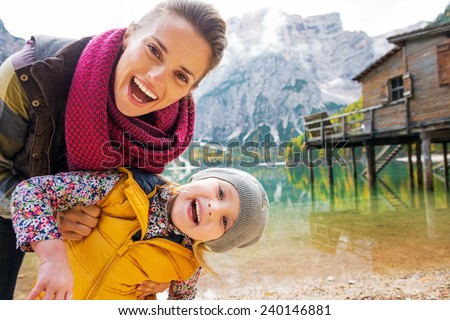Portrait of smiling mother and baby on lake braies in south tyrol, italy