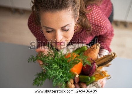 Young housewife enjoying freshness of purchases from local market